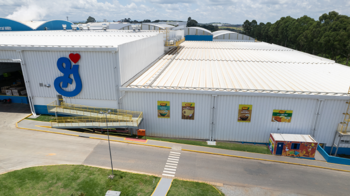 Exterior of a large industrial warehouse with a prominent General Mills logo and several product banners on the walls.