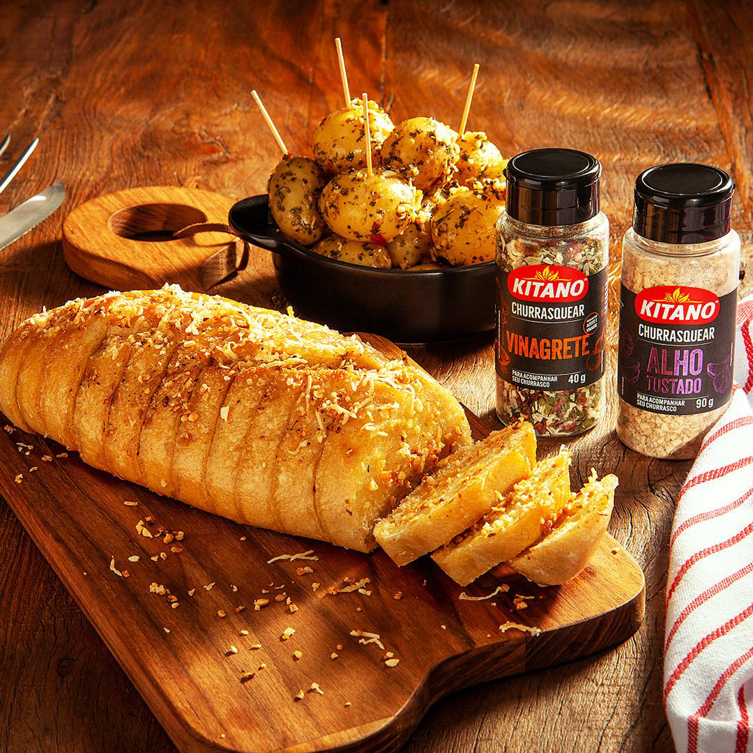 General Mills Brazil - A rustic wooden cutting board with a freshly baked loaf of bread, accompanied by a sprinkle of salt and pepper.